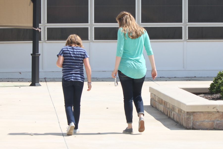 Junior Makenzie Johnson (r) takes a walk with her little sister as part of the Big Brother Big Sister Program.